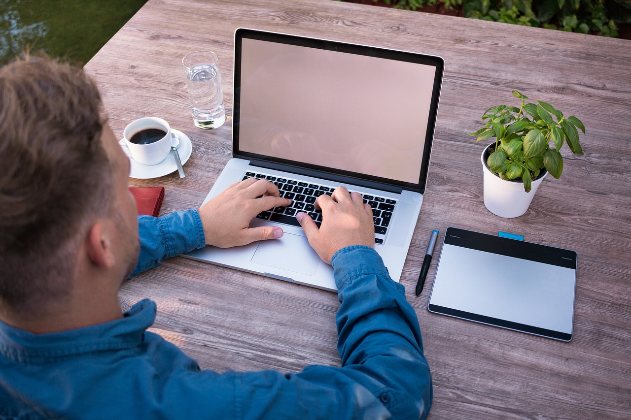 Laptop man outside table plant working